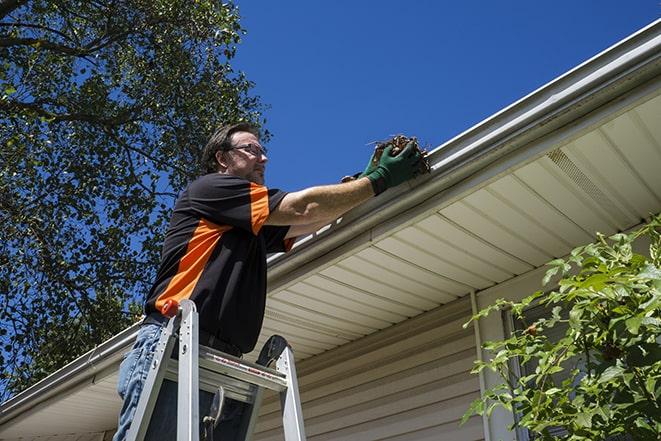 a gutter repair specialist working on a broken downspout in Armuchee, GA